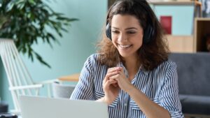 Mulher com fones de ouvido assiste uma aula virtual da Unova cursos gratuitos online